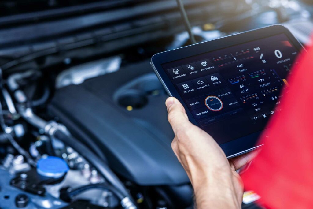 car service mechanic using digital tablet with diagnostics software to check engine condition. vehicle diagnostic inspection Simmonson Automotive